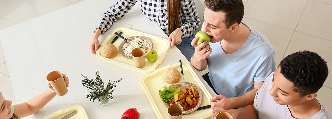 People sitting in cafeteria and eating food