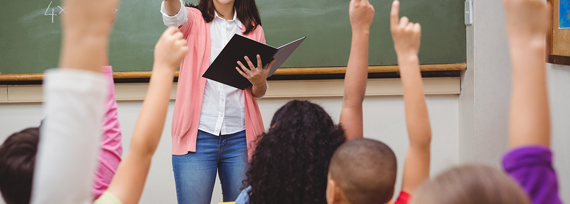 Kids raising hands in the classroom