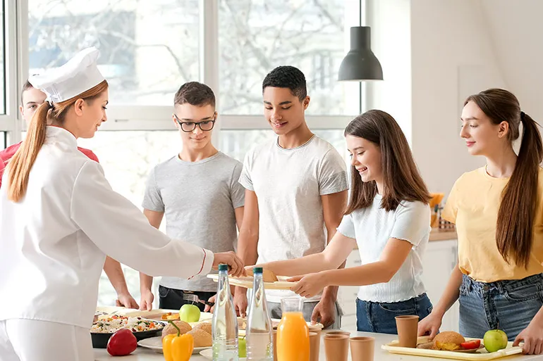 person serving food to kids